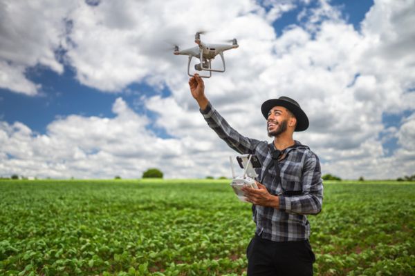 homem utilizando drone para registrar plantação de soja